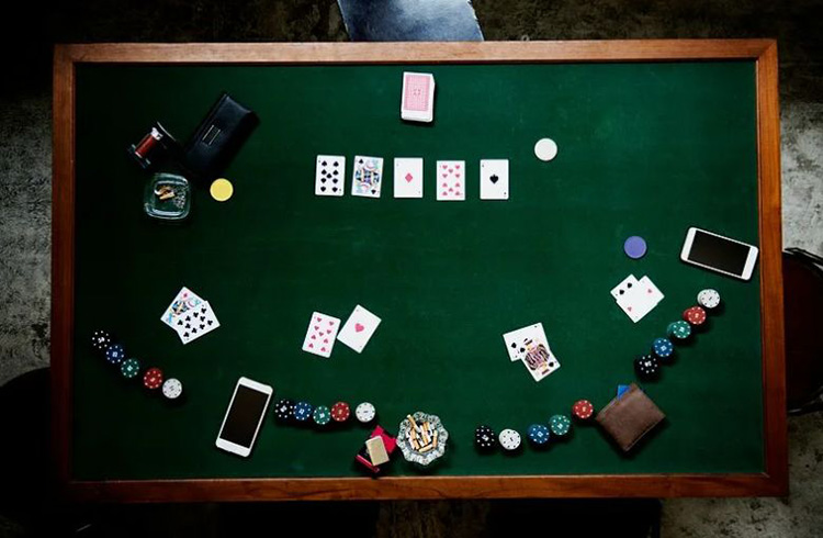 Stół pokerowy i gracze za nim
