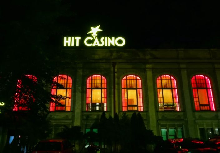 Wejście do Hit Casino w Krakowie przy placu Szczepańskim – neonowa żółta gwiazda