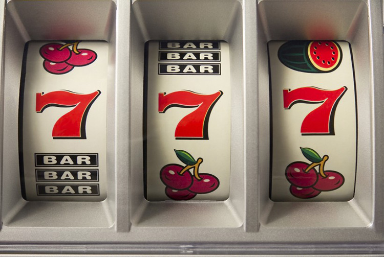 Klasyczny automat z trzema bębnami i symbolami owoców oraz siódemek — retro estetyka kasyna