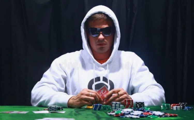 Gracz przy stole pokerowym analizujący karty