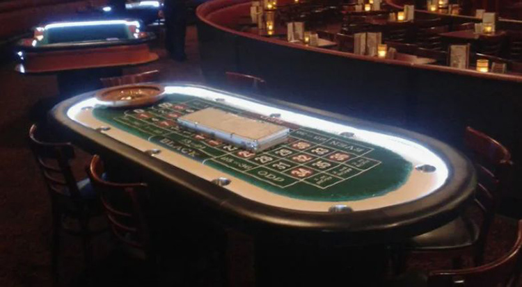 Pokerowy stół w jednym z krakowskich kasyn — zielone sukno, krupier i żetony
