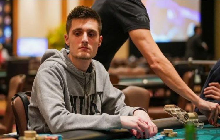 Gracz przy stole pokerowym analizujący karty