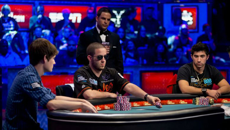 Gracze przy stole finałowym turnieju pokerowego — napięta atmosfera