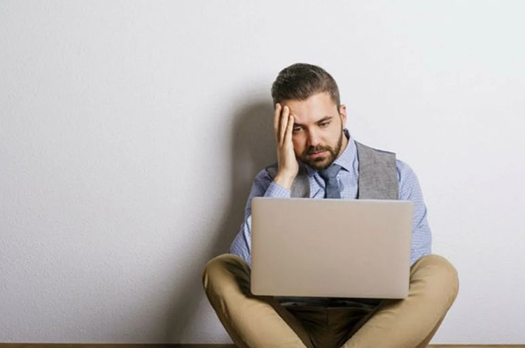 Osoba siedząca przed ekranem komputera z zablokowanym dostępem do kasyna online